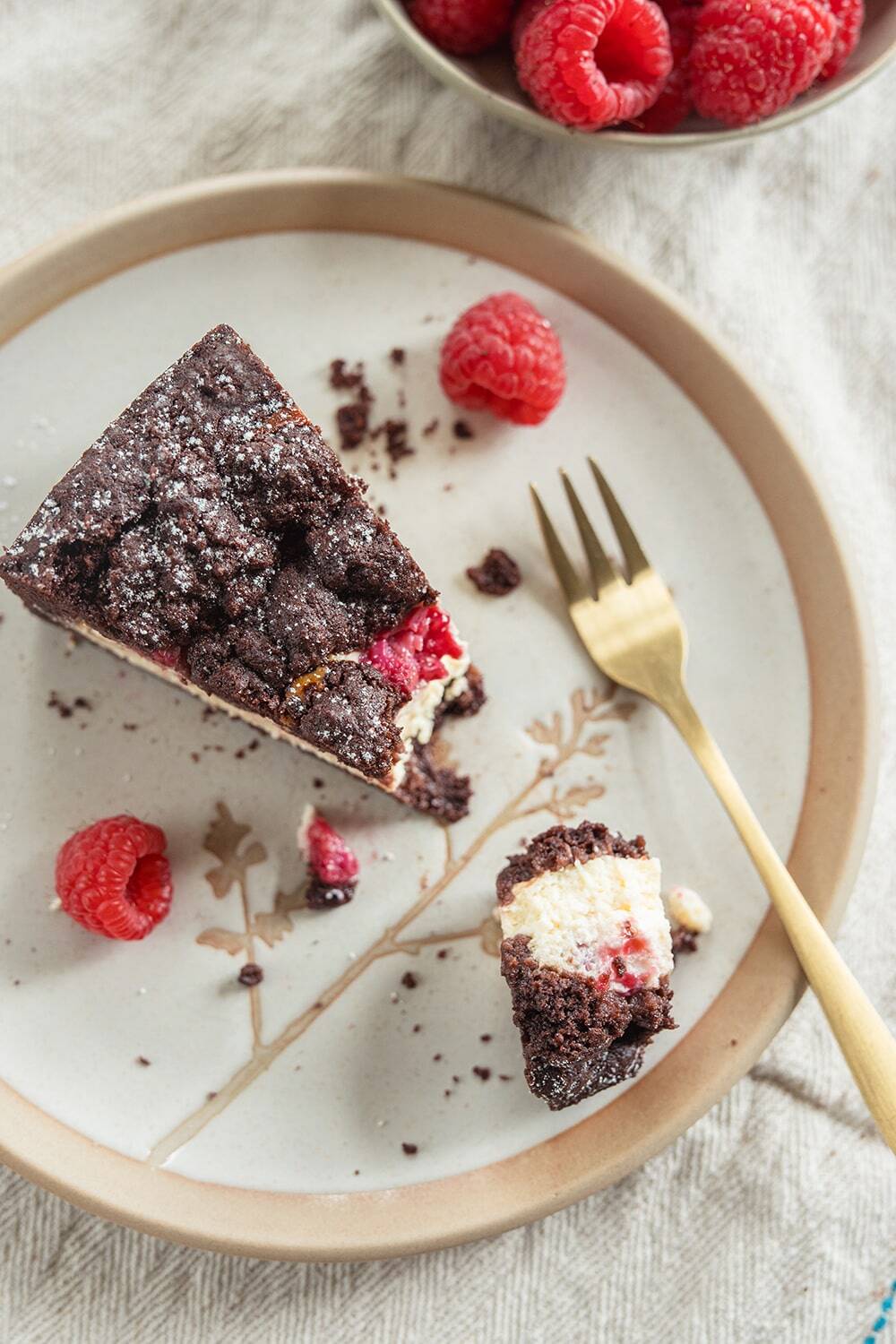 Käsekuchen mit dunklem Boden und Himbeeren
