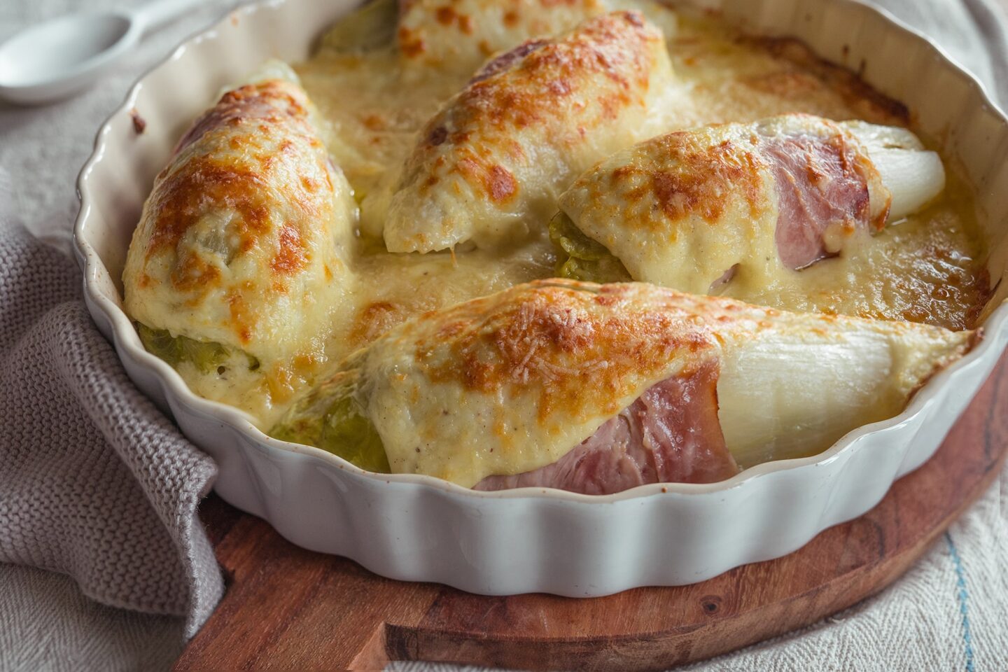 Goldbraun überbackenes Chicorée-Gratin mit cremiger Sauce
